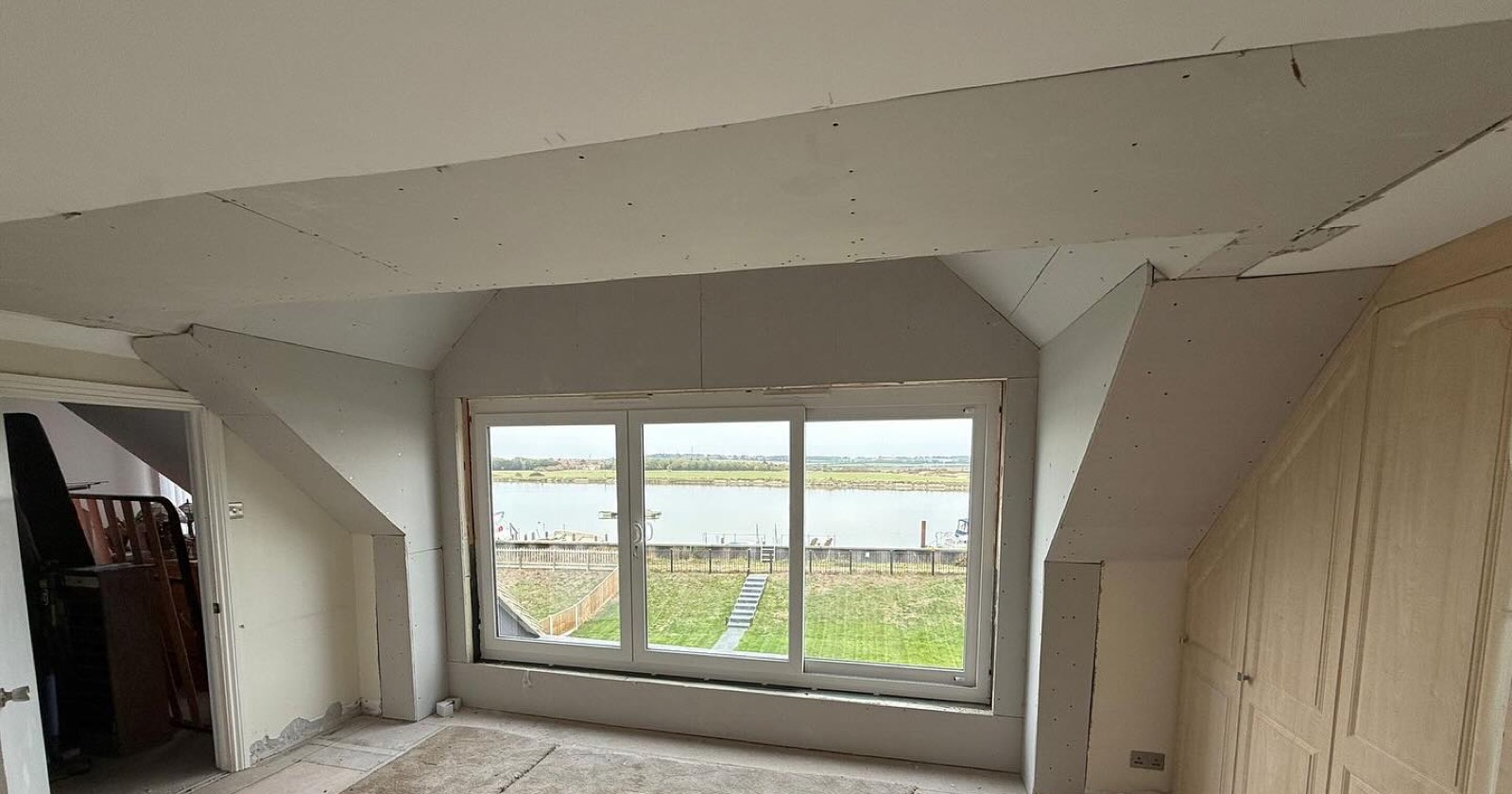 Boarded out room in the roof with a dormer window looking over the river
