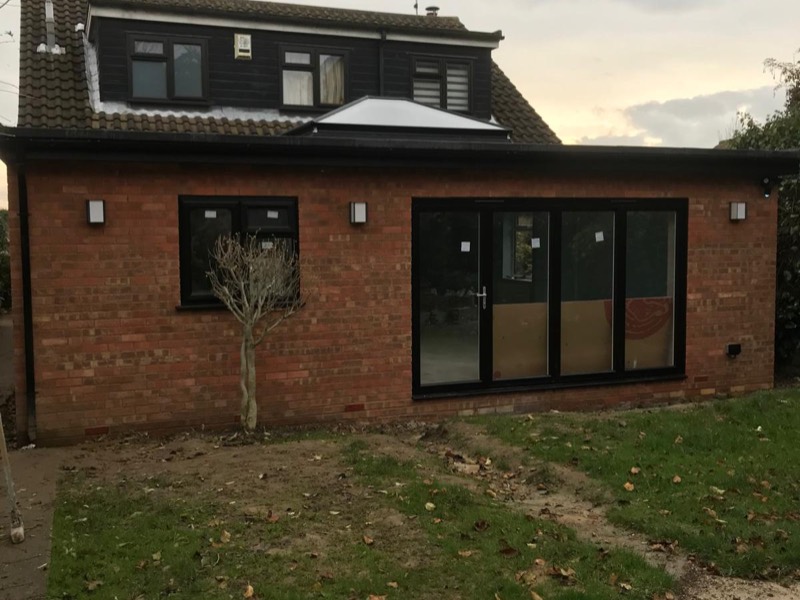 Brick back wall with black bi-fold doors and a roof lantern