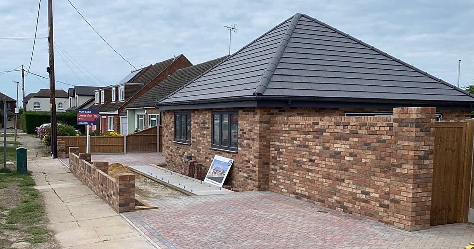 Brick bungalow with a hipped tiled roof and a block paved drive