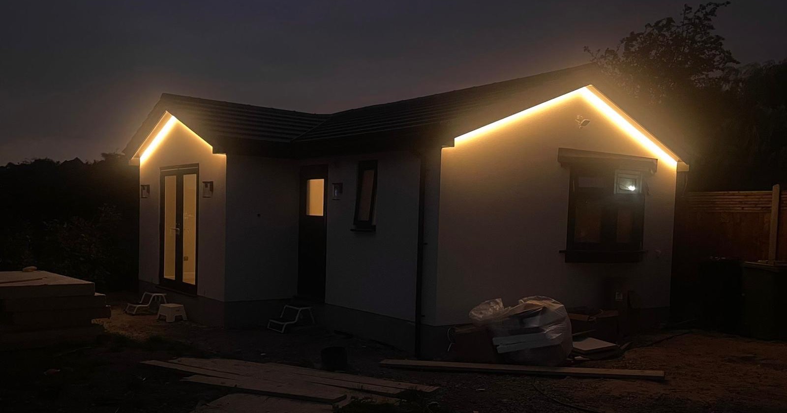 Garden annexe at night with lights along the eaves