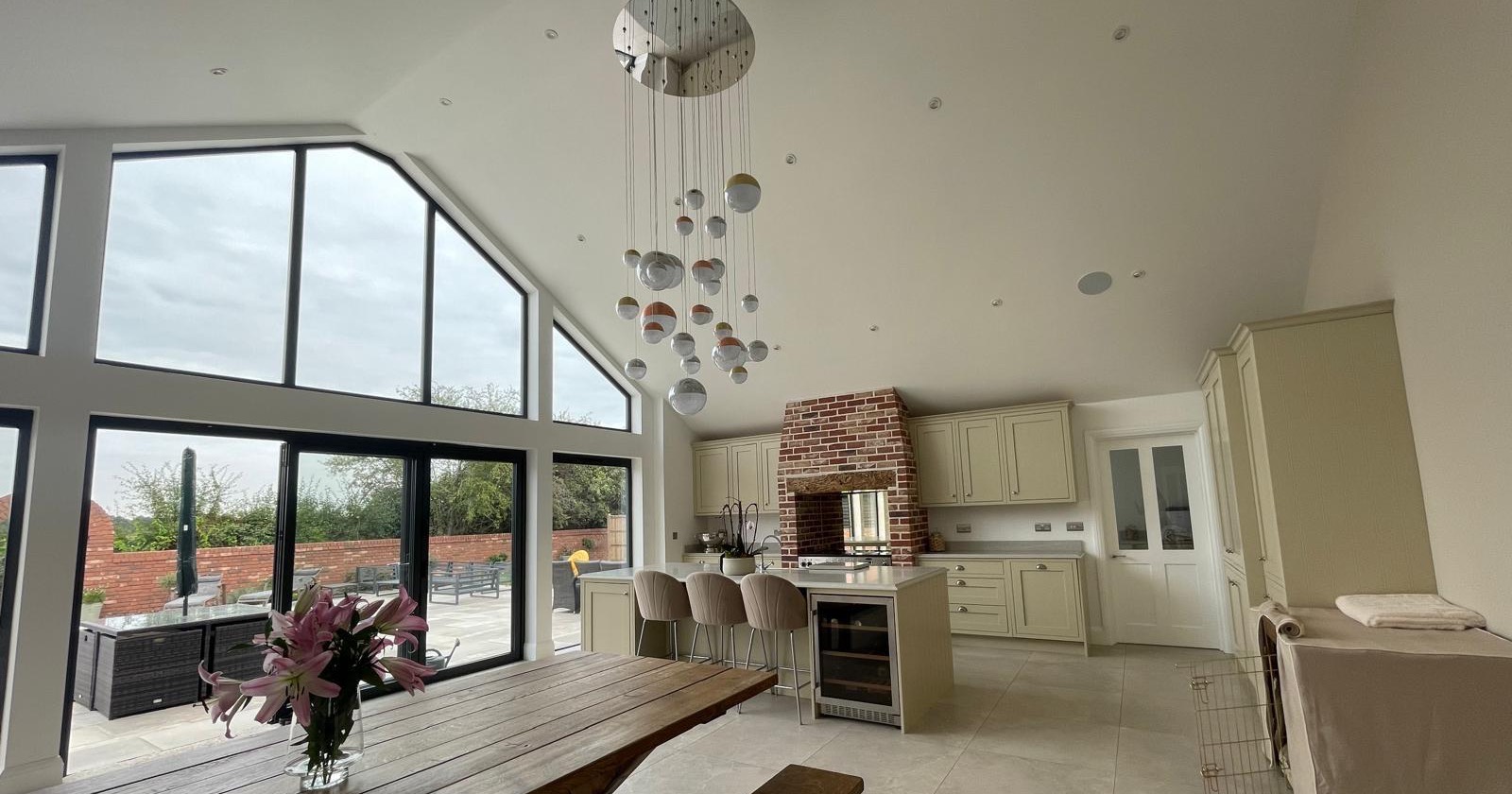 Open plan kitchen diner extension with a vaulted ceiling and a glazed gable opening onto the patio
