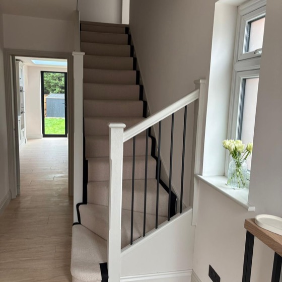 New staircase with black spindles and a carpet runner