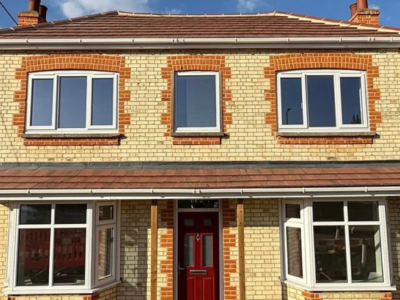 Yellow stock brick with red brick banding around a window